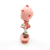 Strawberry Shortcake riding on a skateboard miniature figurine