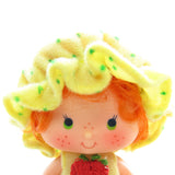 Apple Dumplin doll with red hair, yellow hat
