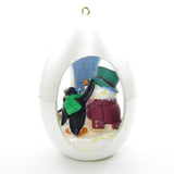 Penguins building snowman ornament