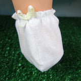 White doll booties with pale yellow bow