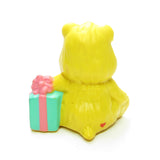 Back of Birthday Bear sitting with a present figurine