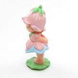 Side view of vintage Avon Little Blossom miniature doll figurine with pink dress