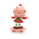 Strawberry Shortcake riding on a skateboard miniature figurine