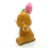 Side of Tenderheart Bear holding heart-shaped balloons figurine