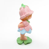 Side view of vintage Avon Little Blossom miniature doll figurine with pink dress