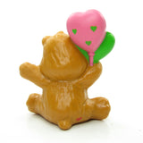 Back of Tenderheart Bear holding heart-shaped balloons figurine