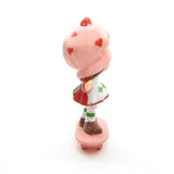 Strawberry Shortcake riding on a skateboard miniature figurine