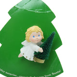 Hallmark angel with blonde hair and blue eyes holding bottle brush tree