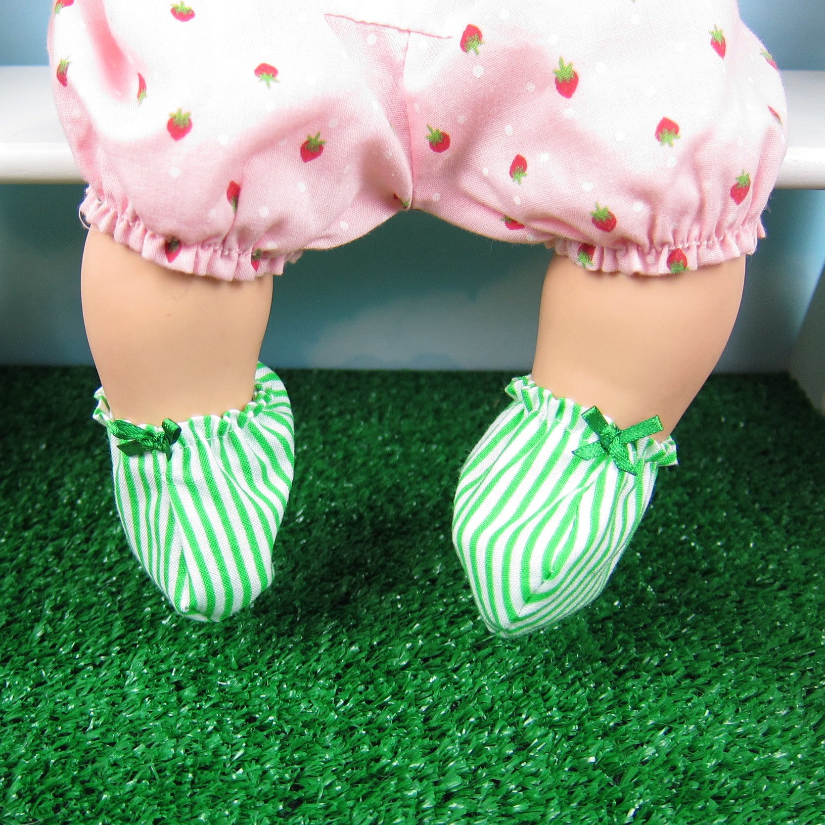 Green and white striped baby booties with green bow