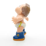 Magic Diapers Baby figurine wearing blue sneakers