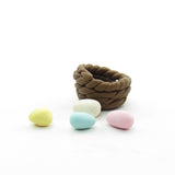 Miniature brown basket with yellow, white, blue and pink Easter eggs