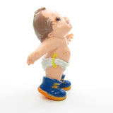 Magic Diapers Baby figurine wearing blue sneakers