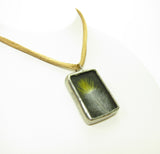 A gray feather with a yellow tip and matching yellow brown necklace makes it a great natural accessory.