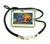 This soldered glass postage stamp pendant hangs from black cord finished with a silver clasp.
