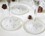 Snowflake paper punches placed under wine glasses make festive decorations for a winter wedding or party.