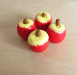 Miniature red wooden apple with yellow top and brown stem