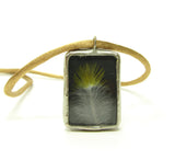 Made with found objects, this necklace includes a real bird feather and upcycled glass.