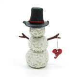 Snowman figurine with snowflakes and twig arms
