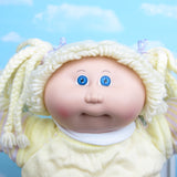 Cabbage Patch Kids girl doll with blonde hair and blue eyes, braided pigtails