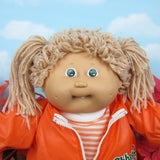 Cabbage Patch Kids girl doll with light brown hair, green eyes, dimples and tooth